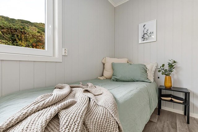 Calm bedroom with green tones symbolising comfort and safety during online hypnotherapy at home
