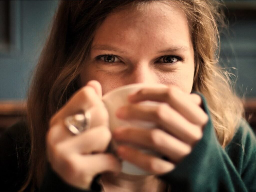 Woman relaxing with a hot drink before an online hypnotherapy session.